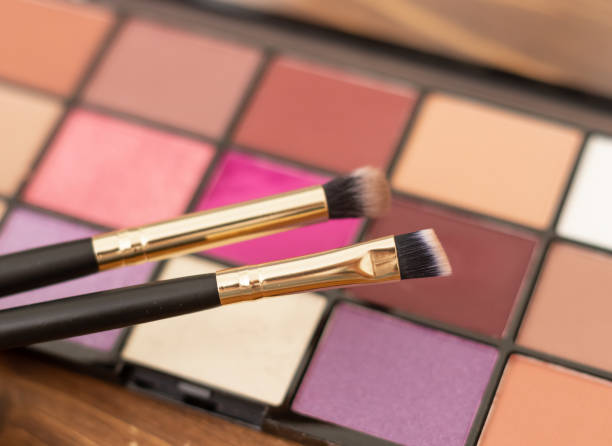 istock palette of bright pink eyeshadows and makeup brushes, close-up 1671352548