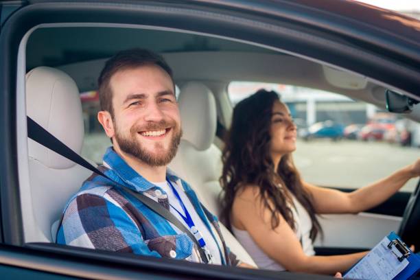 istock Happy male instructor with checklist sitting on the passenger seat while lady driving during drive exam. Driving test, driver courses, exam concept 1671362491