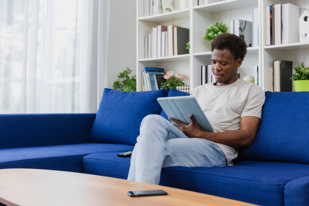 istock Man watching tv at home and ordering food with his digital device. 1671405128
