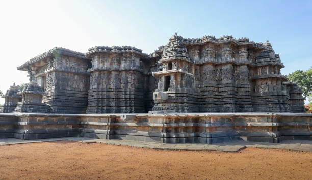 los exteriores de la pared del templo de piedra 'hoysaleshwara' en forma de estrella con esculturas diestras de deidades en halebeedu en karnataka, india. - khajuraho india indian culture temple fotografías e imágenes de stock