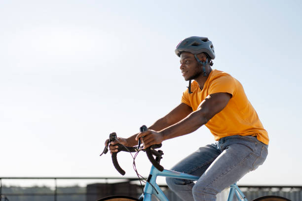 istock Authentic African rider wearing protective helmet and casual clothes riding bicycle, copy space 1671406473