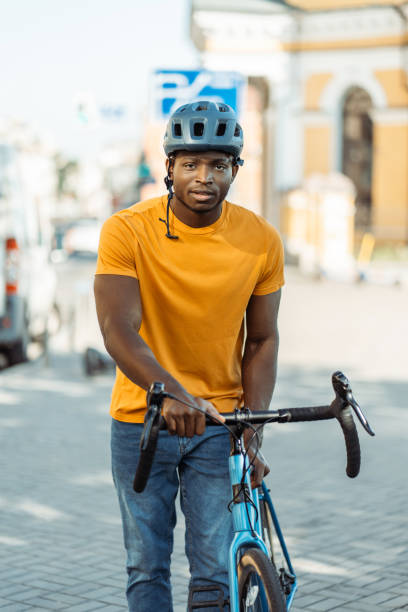 istock Handsome serious African American man wearing helmet riding bicycle and looking camera 1671406767