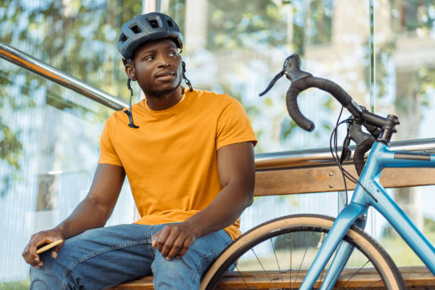 Smiling african american man in safety helmet looking away while relaxing