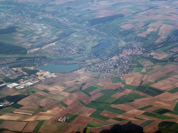 istock View from above of different colored fields, forests and small towns below. View from the plane 1671420559