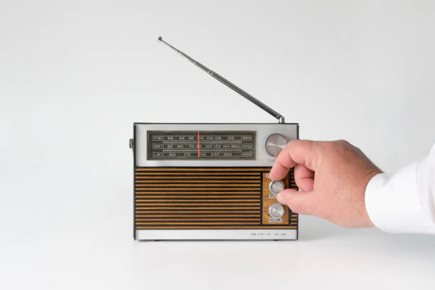 istock A man's hand twists the wave setting. Authentic radio from the 70s. Isolated on white background. Traces of time and scuffs on the case 1671450675