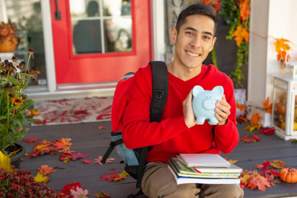 istock Happy University student holding piggy bank 1671463356