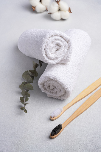 Eco-friendly bathroom products. Loofah, bamboo toothbrushes and white towels. Bathroom and spa accessories for sustainable lifestyle. Zero waste concept.