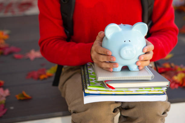 University student holding blue piggy bank