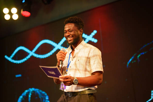 istock Speeker talking and showing a presentation to audience on stage with microphone 1671470375