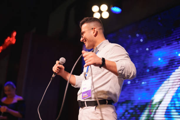 istock Speeker talking and showing a presentation to audience on stage with microphone 1671476964