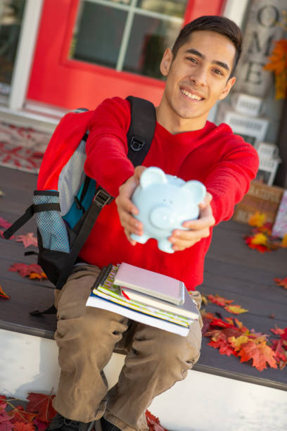 istock Happy University student holding piggy bank 1671488089