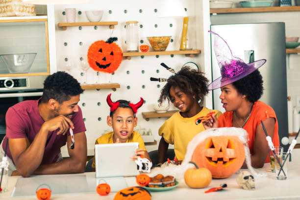 istock Family has fun in Halloween time make video call with digital tablet. 1671488091