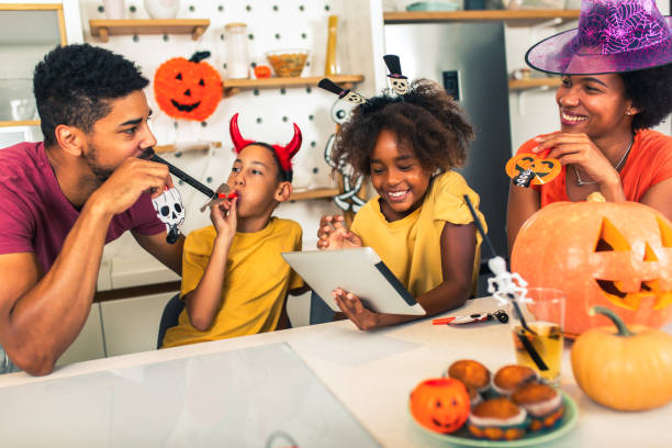 istock Family has fun in Halloween time make video call with digital tablet. 1671488096