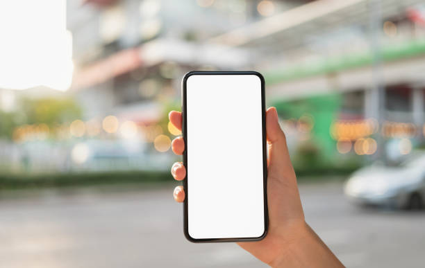 istock Hand holding black smartphone with blank screen for graphic display montage at shopping mall background. 1671494643