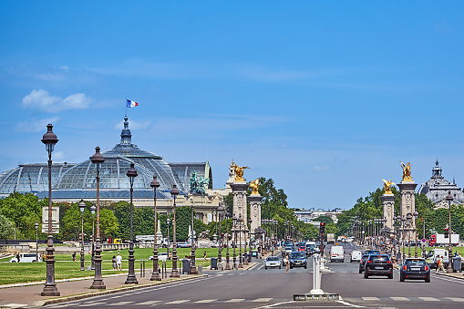 Paris, France - July 11, 2023: Pedestrians and traffic on Avenue du Marechal Gallieni. In the background the Grand Palais.