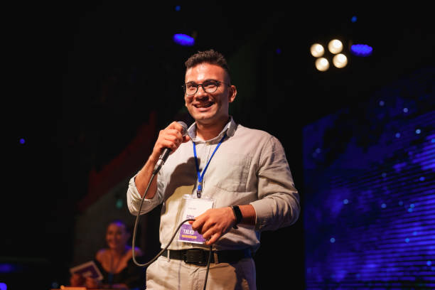istock Speeker talking and showing a presentation to audience on stage with microphone 1671509030