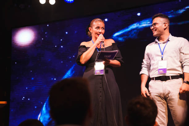 istock Speeker talking and showing a presentation to audience on stage with microphone 1671533920