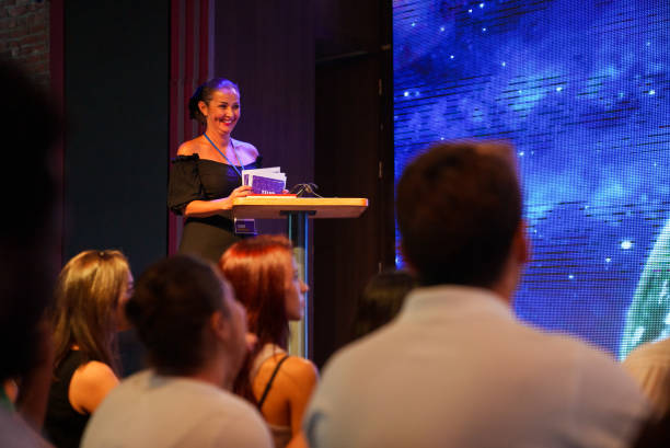 istock Speeker talking and showing a presentation to audience on stage with microphone 1671542405