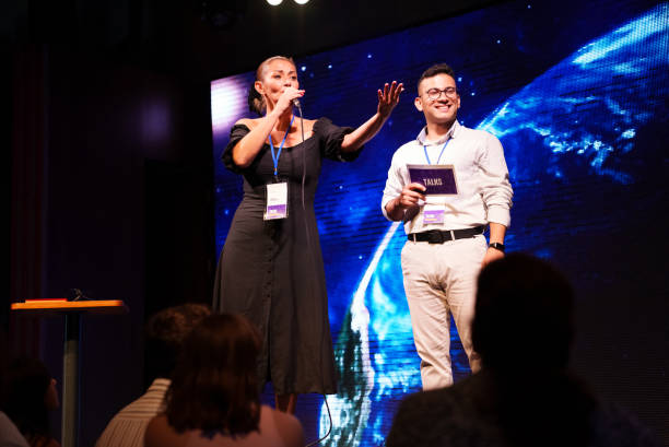 istock Speeker talking and showing a presentation to audience on stage with microphone 1671542420