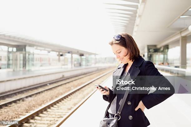 Foto de Viagemusando Smartphone Na Estação De Trem e mais fotos de stock de 30 Anos - 30 Anos, Adulto, Adulto de idade mediana