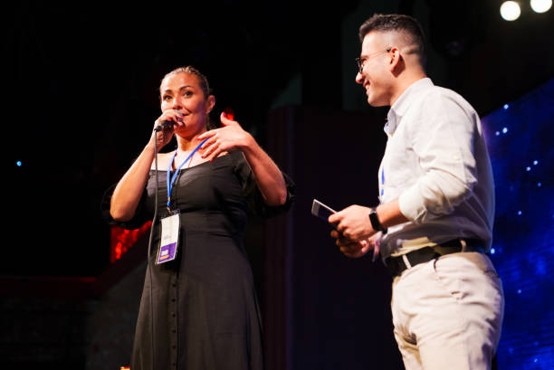 istock Speeker talking and showing a presentation to audience on stage with microphone 1671547350