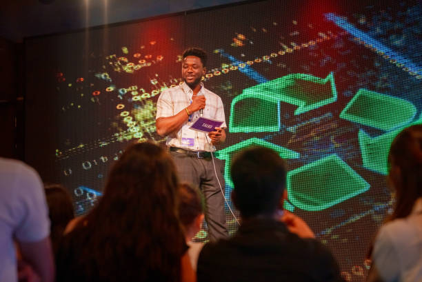 istock Speeker talking and showing a presentation to audience on stage with microphone 1671554681