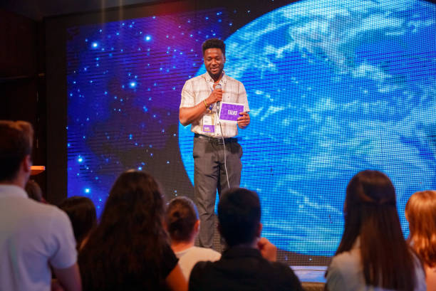 istock Speeker talking and showing a presentation to audience on stage with microphone 1671554685