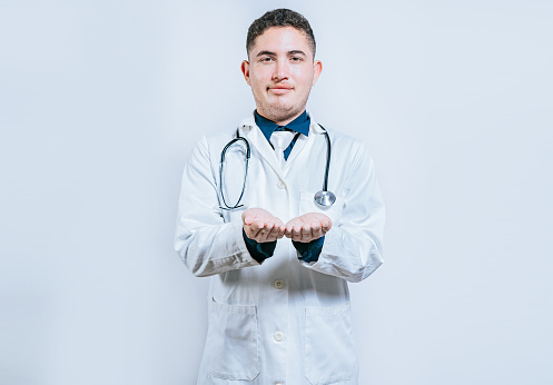 Hands of young doctor presenting something empty-handed. Doctor with hands together and empty. Doctor holding something in his hands isolated