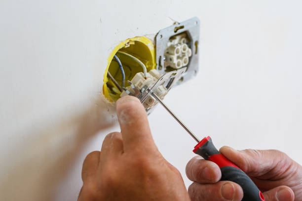 istock An electrician installs a socket in the wall. 1671580473