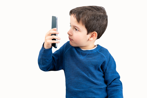 Boy suffering from eyestrain trying to read a message on a smart phone with white background.