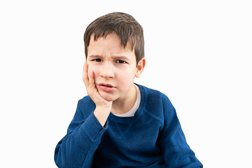 Stressed child complaining suffering toothache with white background.