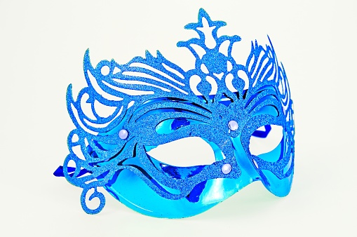 A masquerade mask hangs on a brick wall. Decoration of the room for the celebration of the carnival.