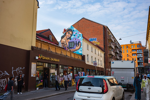 Oslo, Norway, June 20, 2023: A city street sceen in an Afghan neighborhood in Oslo during a summer day. A food market is visited by customers.