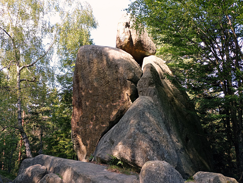 Giant stones in the middle of the Carpathian forest. Green Carpathian forest in the Ukrainian mountains. Beautiful stone rocks.