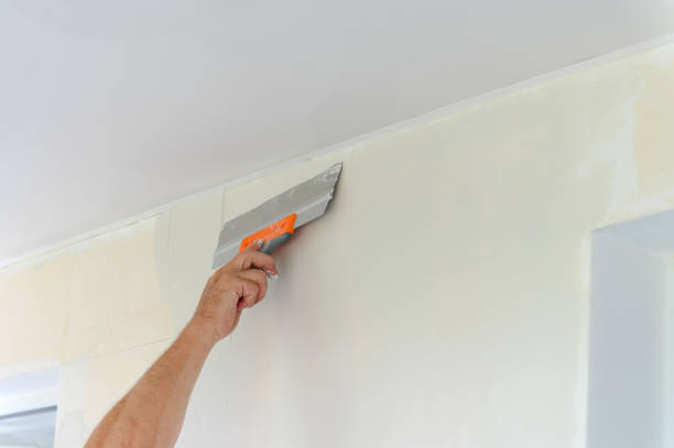 istock Worker trowels putty on drywall with finishing putty 1671672951