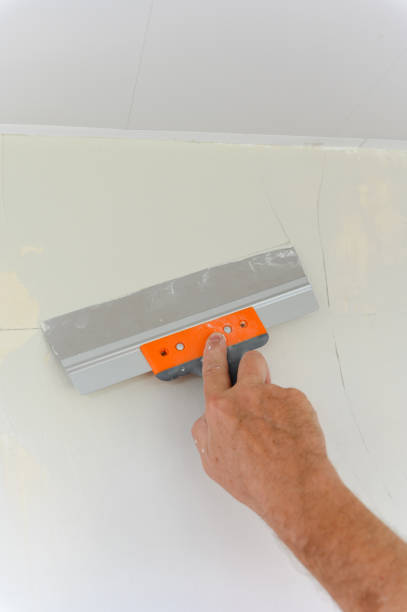 istock Worker trowels putty on drywall with finishing putty 1671672953