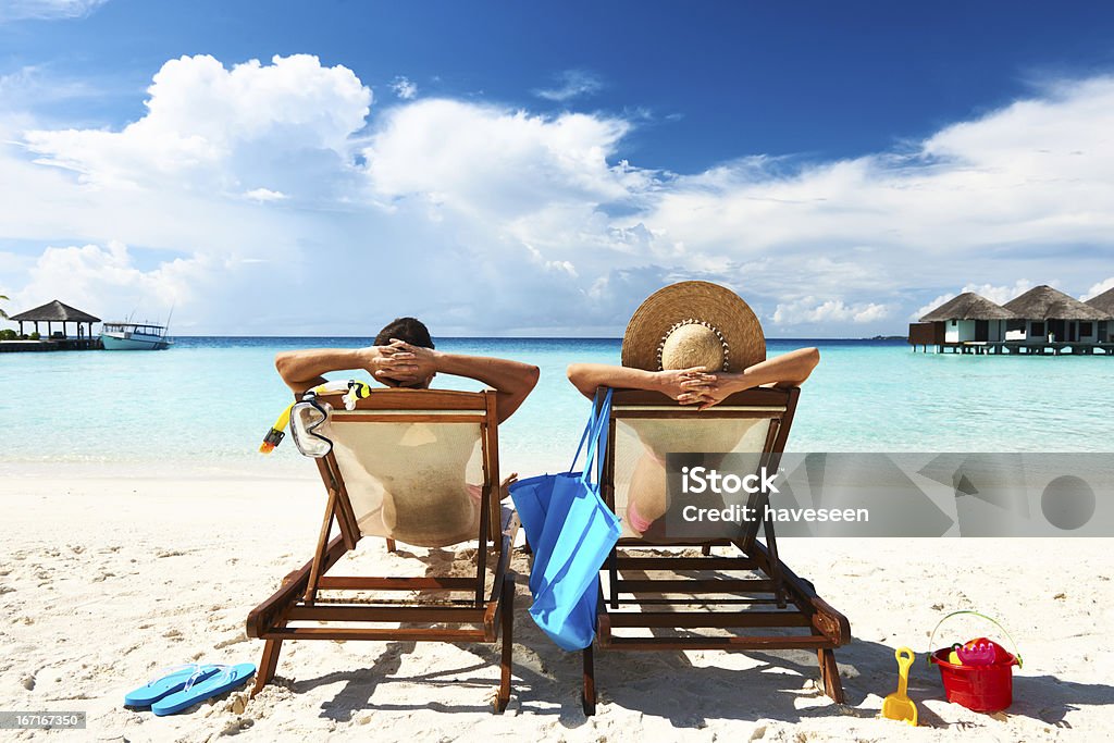 Couple on a beach Couple on a tropical beach at Maldives Beach Holiday Stock Photo