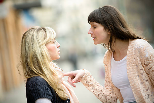 Two women arguing on the street Two women talking to each other and arguing. spar stock pictures, royalty-free photos & images