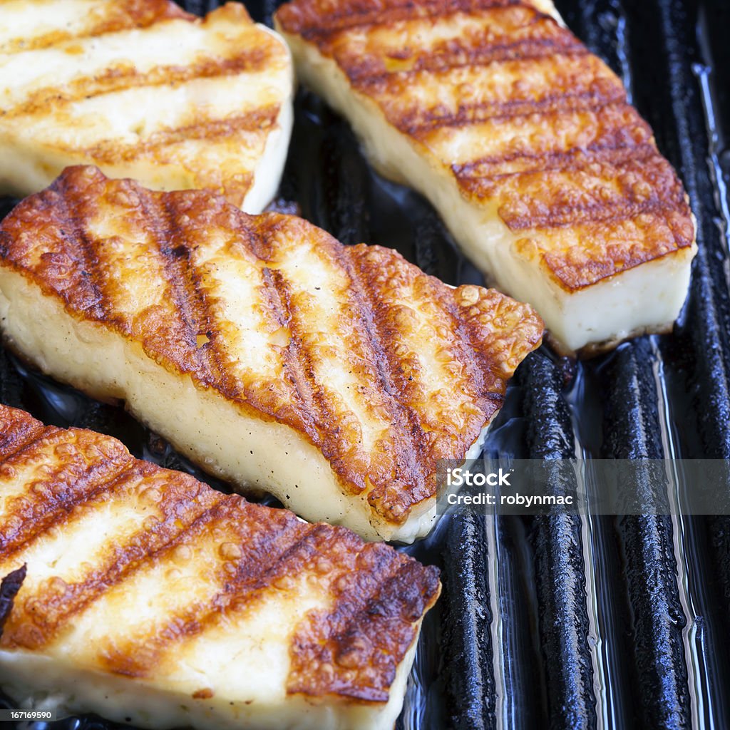 Grilling Halloumi Cheese Halloumi cheese frying in grill pan. Halloumi Stock Photo