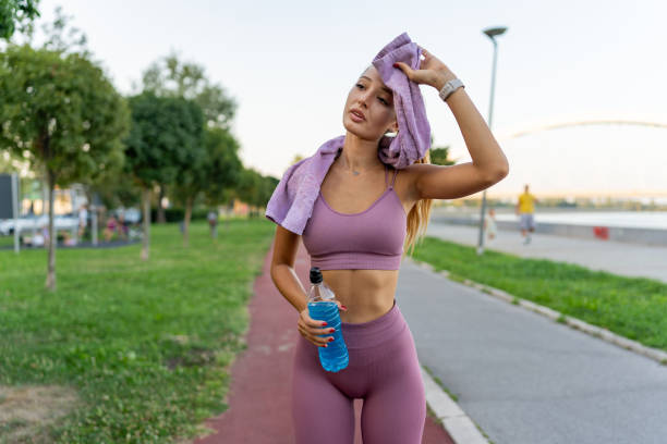 istock Young female jogger wiping off sweat after a run 1671709652