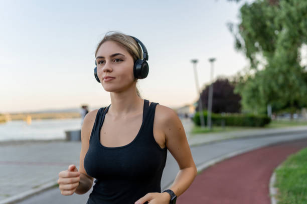 istock Young Caucasian woman wearing wireless headphones while jogging 1671710702