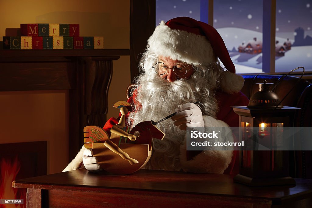 Father Christams painting a toy in his workshop Portrait of Father Christams painting a toy in his workshop Santa Claus Stock Photo
