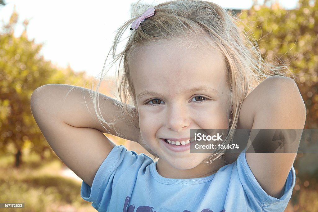 Smiling Little Girl A nice little girl is smiling happily crossing the arms behind the head. 4-5 Years Stock Photo
