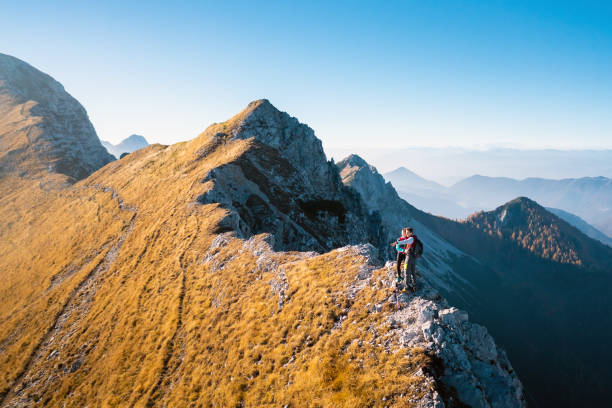istock Hiker couple hugging and looking at the mountains 1671728744