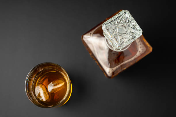 glass and bottle of whiksy on a black background - whisky liqueur glass alcohol bottle imagens e fotografias de stock