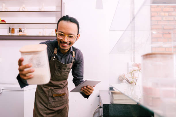 istock Asian barista checking stock using digital tablet. 1671775839