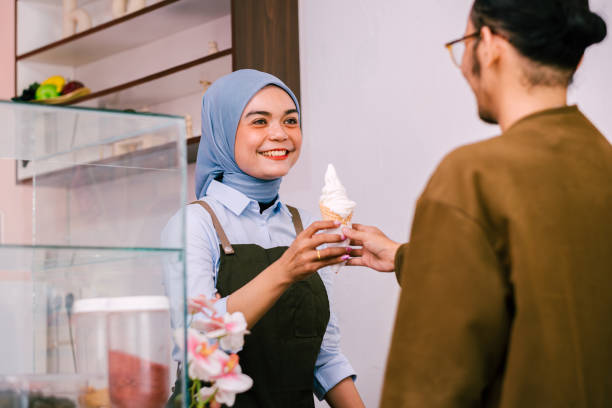 istock Asian employee giving an ice cream for her customer. 1671775849