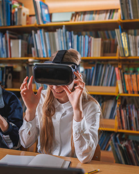 istock Girl using devices in the library, a laptop and VR headset 1671798617