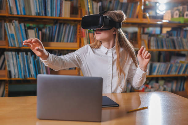 istock Girl using devices in the library, a laptop and VR headset 1671800231