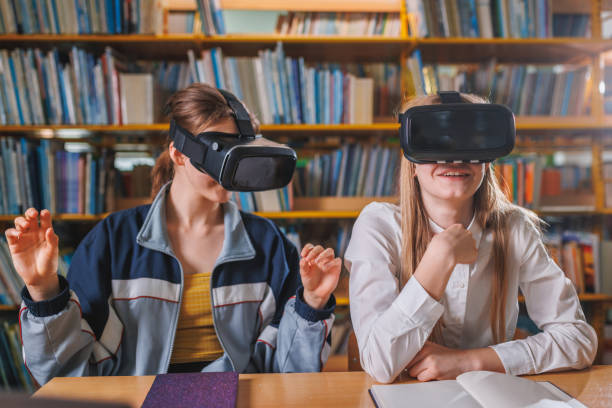 istock Smiling girl students enjoying VR experience in the school library 1671802428